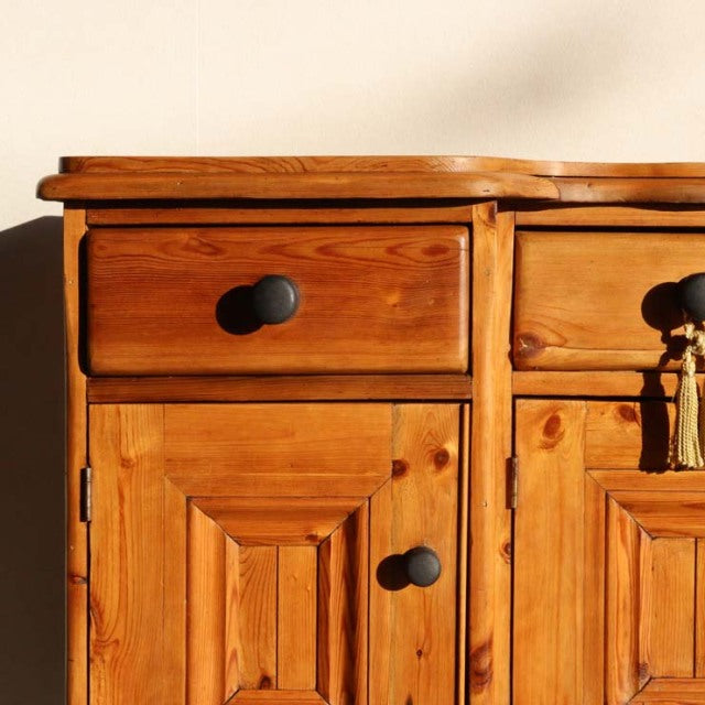 Mid-century vintage teak sideboard with rich wood grain, black round knobs, and paneled doors, British-Danish style.