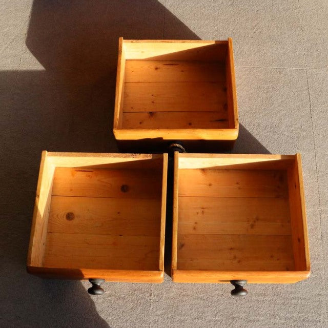 Three open vintage teak drawers with visible wood grain and round black metal handles, mid-century British style design.