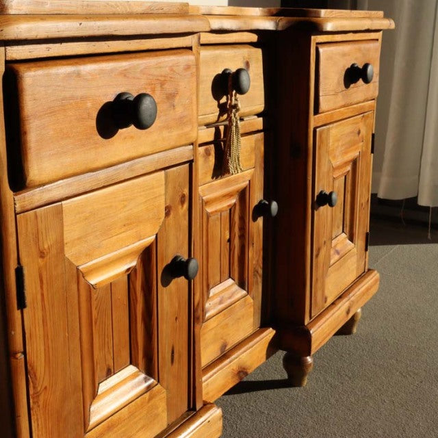 Vintage teak mid-century British sideboard with rich wood grain, panel doors, and black round knobs.
