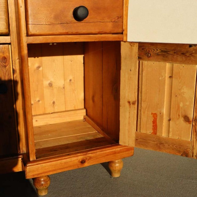 Vintage British mid-century teak sideboard with warm wood grain, rounded legs, and paneled door interior.