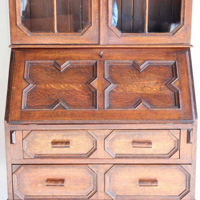 Vintage 1930s British teak antique cabinet with geometric wood grain pattern and mid-century style legs.