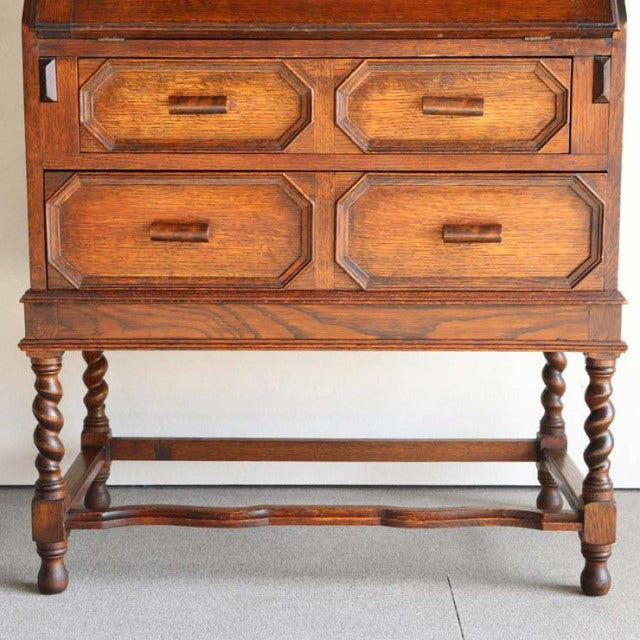 Vintage 1930s British teak cabinet with rich wood grain, four drawers, and twisted mid-century turned legs from Denmark.