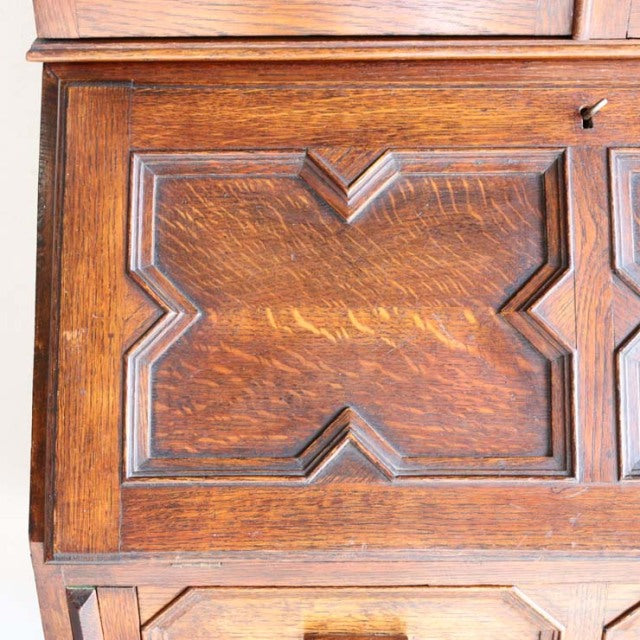 Close-up of vintage teak cabinet door showcasing rich wood grain and British mid-century geometric panel design.
