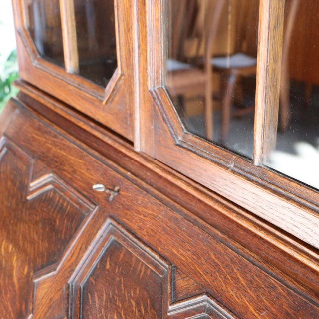 Vintage British teak cabinet with mid-century design, detailed wood grain, beveled glass doors, and ornate paneling.
