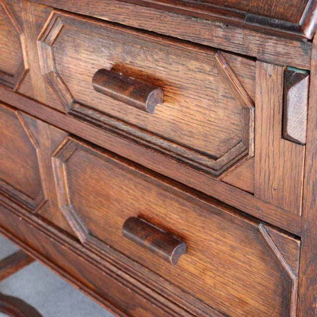 Close-up of vintage British mid-century teak cabinet drawers featuring rich wood grain and rounded wooden handles.