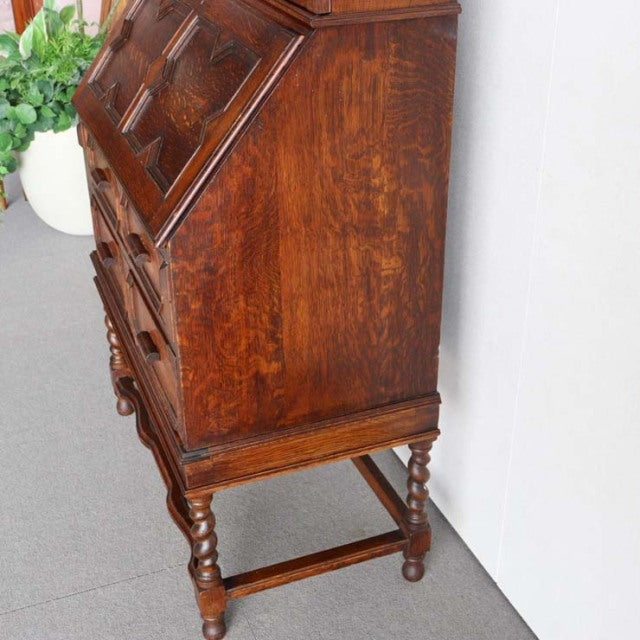 Vintage 1930s British teak cabinet with rich wood grain, turned legs, and mid-century Danish design influence.
