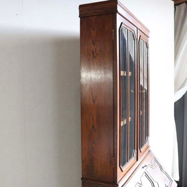 Vintage mid-century British teak cabinet with rich wood grain, glass-paneled doors, and tapered legs in Danish style.