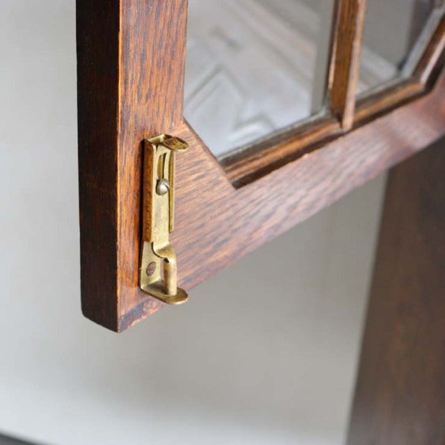 Close-up of vintage teak cabinet door corner with British mid-century brass latch and visible wood grain from Denmark design.