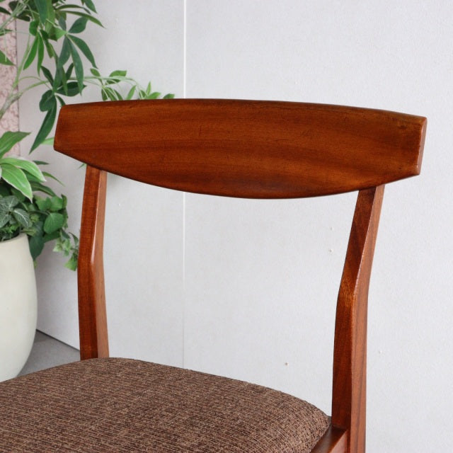 Mid-century British teak dining chair by McIntosh with curved backrest and brown upholstered seat.