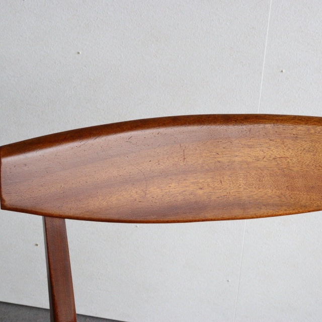 Mid-century British McIntosh dining chair with curved teak backrest showcasing rich wood grain and warm finish.