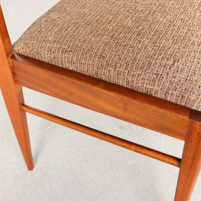 Vintage McIntosh mid-century teak dining chair leg and seat corner with textured beige fabric upholstery, British design.