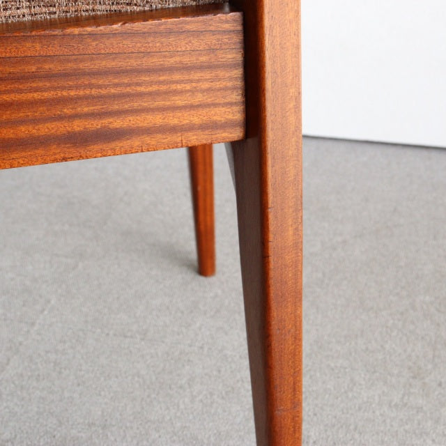 Close-up of vintage British mid-century teak dining chair leg and frame showing rich wood grain and smooth finish from.
