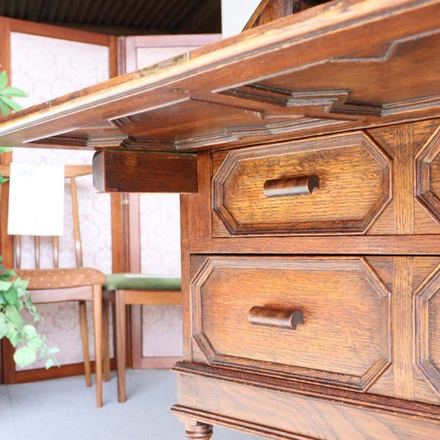 Vintage teak mid-century British cabinet with rich wood grain, detailed drawer fronts, and sturdy legs.