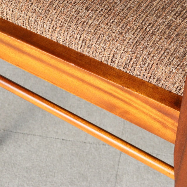 Close-up of vintage teak wood grain and beige textured fabric upholstery on British mid-century McIntosh dining chair from.