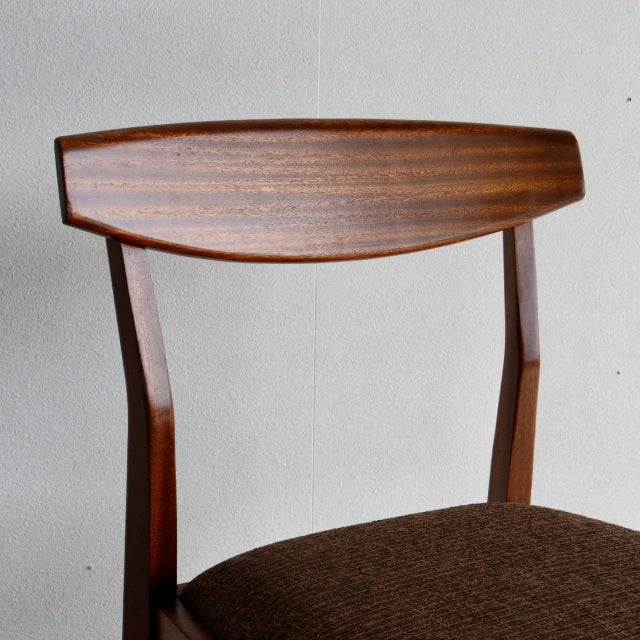 Vintage mid-century McIntosh teak dining chair from Britain with curved grain wood backrest and brown upholstered seat.