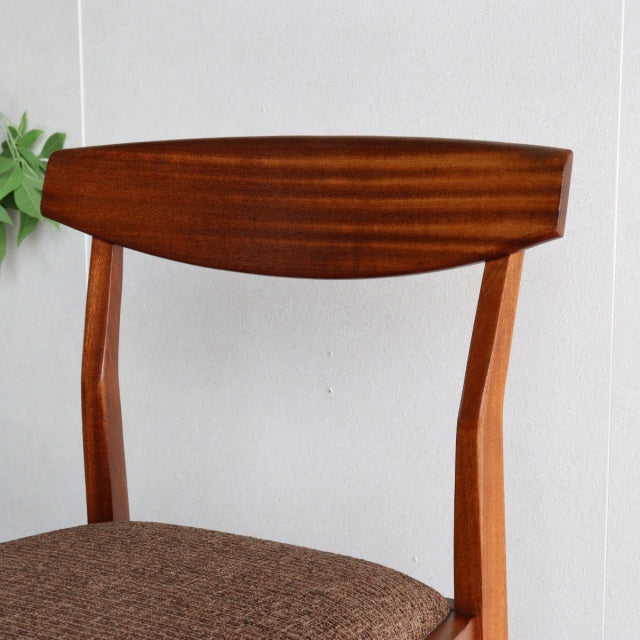 Vintage McIntosh teak dining chair with curved backrest, mid-century British design, angled legs, and textured brown fabric.