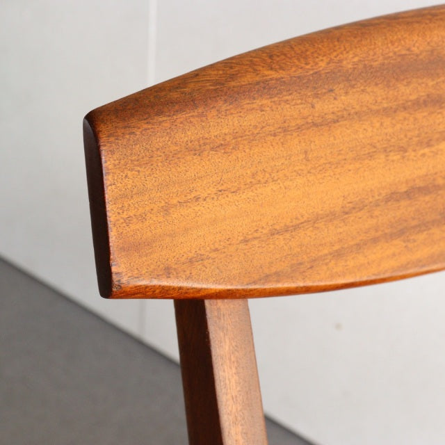 Mid-century British McIntosh teak dining chair backrest showing smooth wood grain and angled edges, vintage Denmark style.