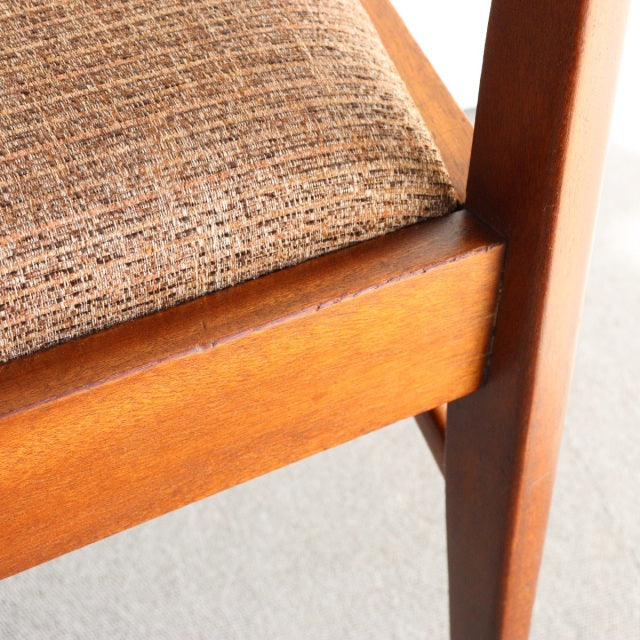 Close-up of vintage teak dining chair by McIntosh showing wood grain, mid-century British design, and textured neutral.