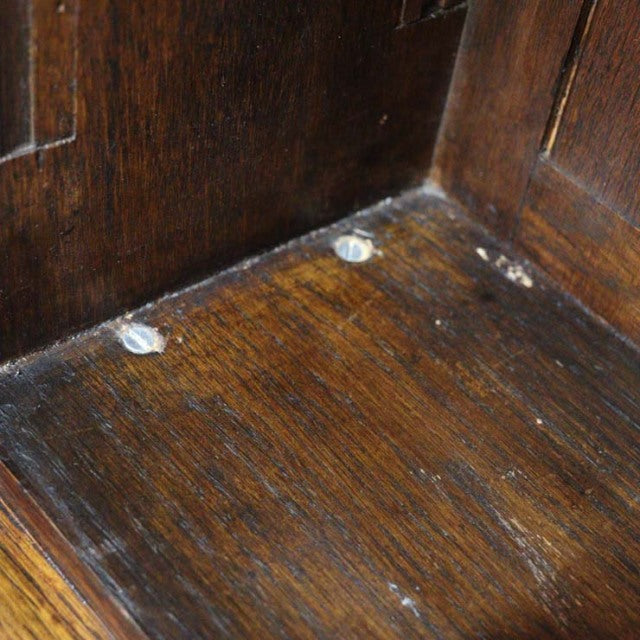Close-up of vintage teak wood grain on a British mid-century 1930s cabinet interior corner showing aged patina and screw.