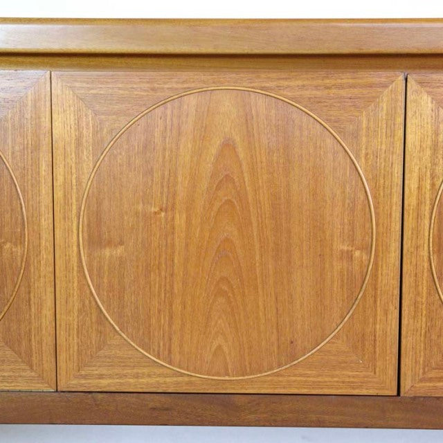 Close-up of vintage British Nathan teak sideboard door featuring mid-century circular wood grain design and smooth finish.
