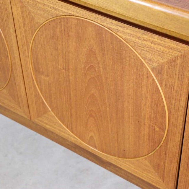 Vintage mid-century teak sideboard by British brand Nathan with distinctive circular door detail and natural wood grain.