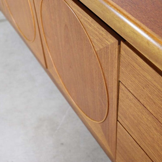 Mid-century British vintage teak sideboard by Nathan with distinctive circular door inlay and smooth wood grain detailing.