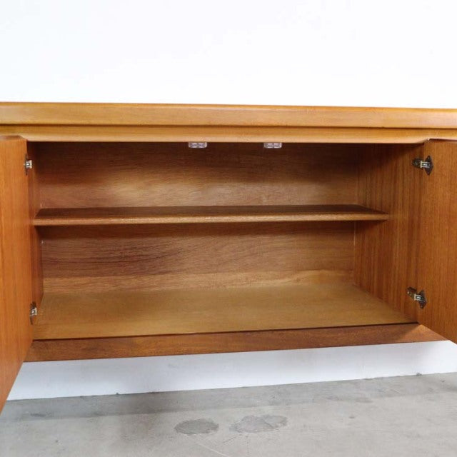 Mid-century British vintage teak sideboard by Nathan with open double doors, showcasing wood grain and interior shelf.