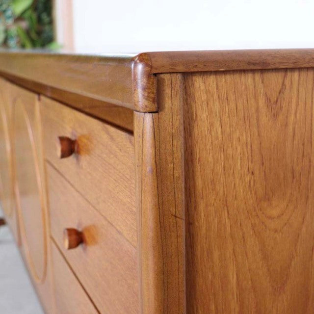 Mid-century British teak sideboard by Nathan featuring rich wood grain, rounded edges, and distinctive wooden knobs.