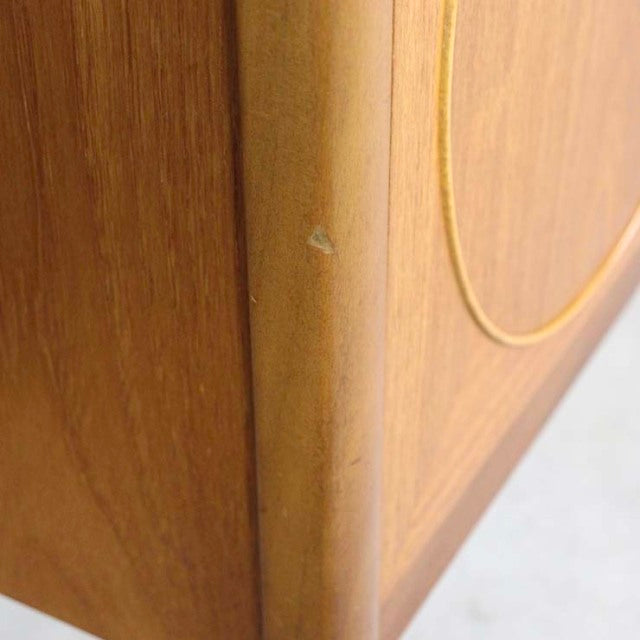 Close-up of vintage teak sideboard corner showing smooth wood grain and rounded edge, mid-century British craftsmanship by.