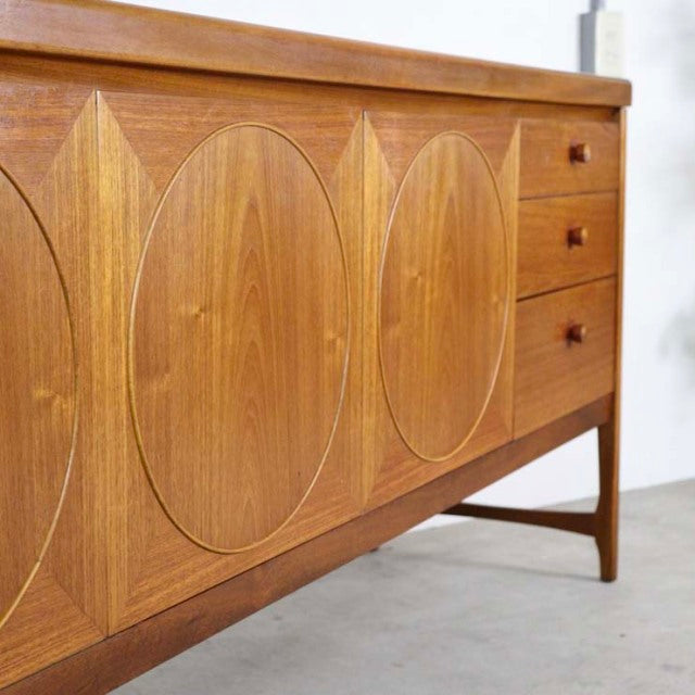 Vintage British teak sideboard with distinctive oval wood grain patterns, three drawers on the right, tapered legs,.