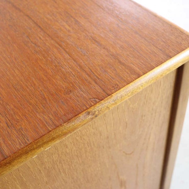Close-up of vintage British Nathan teak sideboard corner showing smooth wood grain and mid-century craftsmanship detailing.