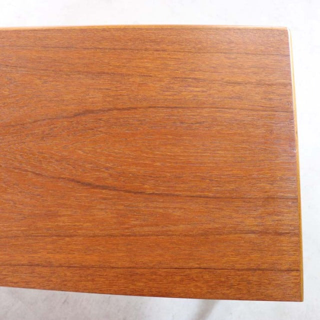 Close-up of vintage teak wood grain on British mid-century Nathan circle sideboard top panel with smooth finish.