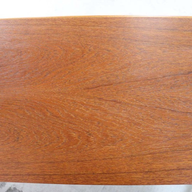 Vintage teak sideboard surface showcasing rich wood grain with warm mid-century British craftsmanship cues.