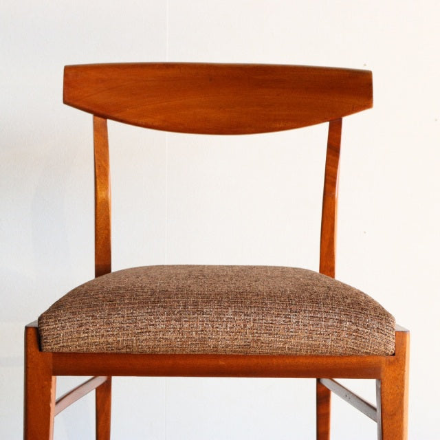 Vintage McIntosh mid-century teak dining chair from Denmark with curved backrest and textured brown seat upholstery.