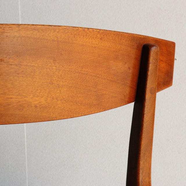 Mid-century vintage teak McIntosh dining chair backrest with smooth wood grain and dark tapered legs.