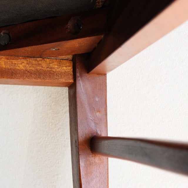 Close-up of mid-century vintage teak wood joint on McIntosh British dining chair showing smooth wood grain and clean.