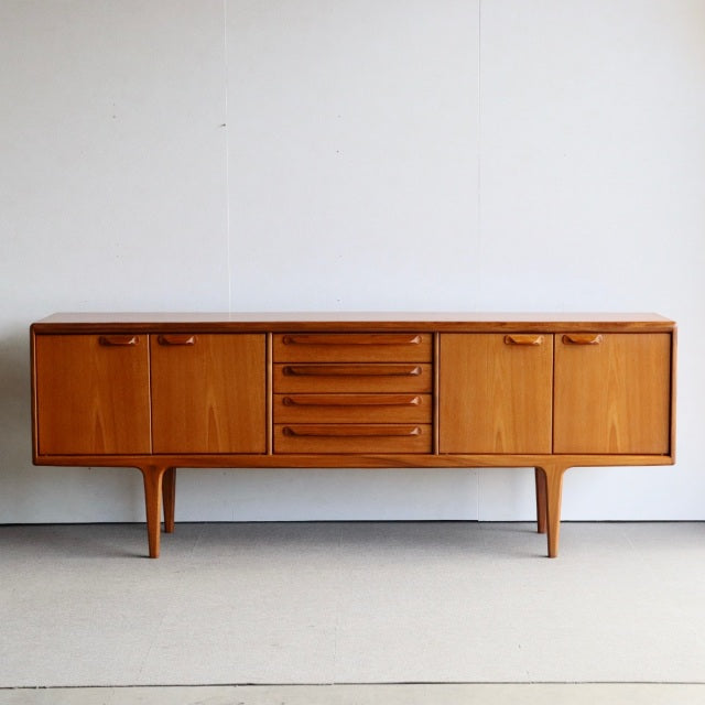 Mid-century British vintage teak sideboard by Younger with smooth wood grain, central drawers, and tapered legs.