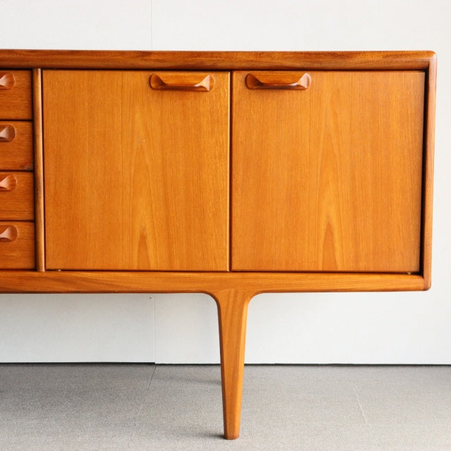 Mid-century British vintage teak sideboard by Younger with warm wood grain, curved drawer handles, and tapered legs from.