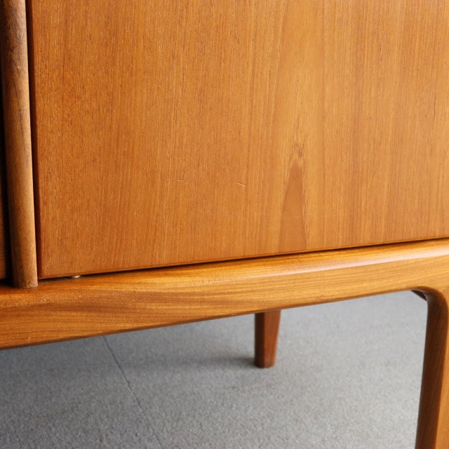 Vintage teak sideboard by Younger from mid-century British design, showcasing smooth wood grain and slender tapered legs.