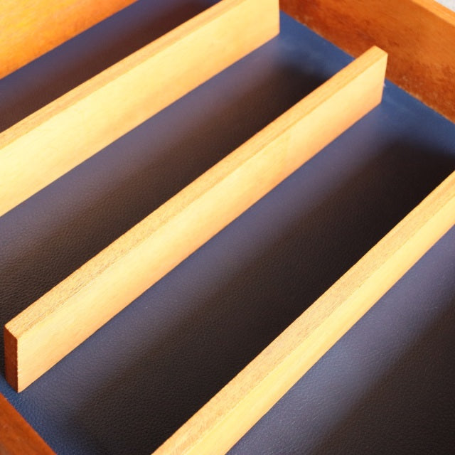 Close-up of vintage teak sideboard drawer interior with smooth wood grain and mid-century British design elements.