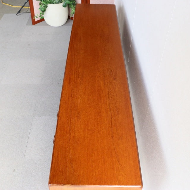 Long vintage teak sideboard by Younger, British mid-century design with rich wood grain and tapered legs, from Denmark.