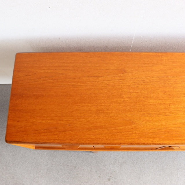 Mid-century British vintage teak sideboard by Younger with smooth wood grain and sleek rectangular top.