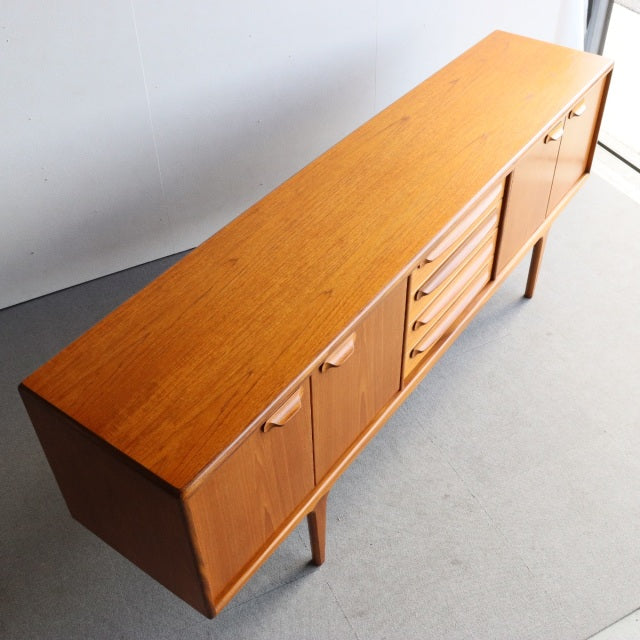 Mid-century British vintage teak sideboard by Younger with clean lines, visible wood grain, tapered legs, and combination of .