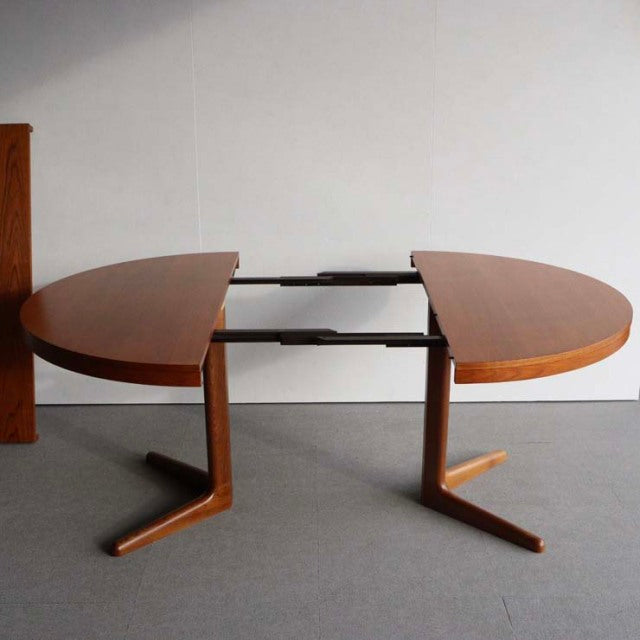 Vintage Edward Valentinsen round mid-century dining table in warm teak with extendable top and angled British-Denmark style.