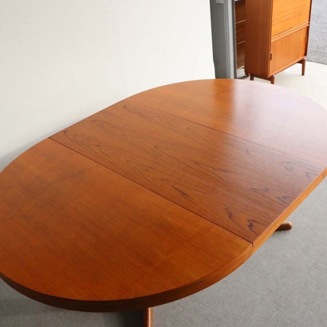 Vintage mid-century teak round dining table by Edward Valentinsen, smooth wood grain, slender tapered legs, Danish-British.