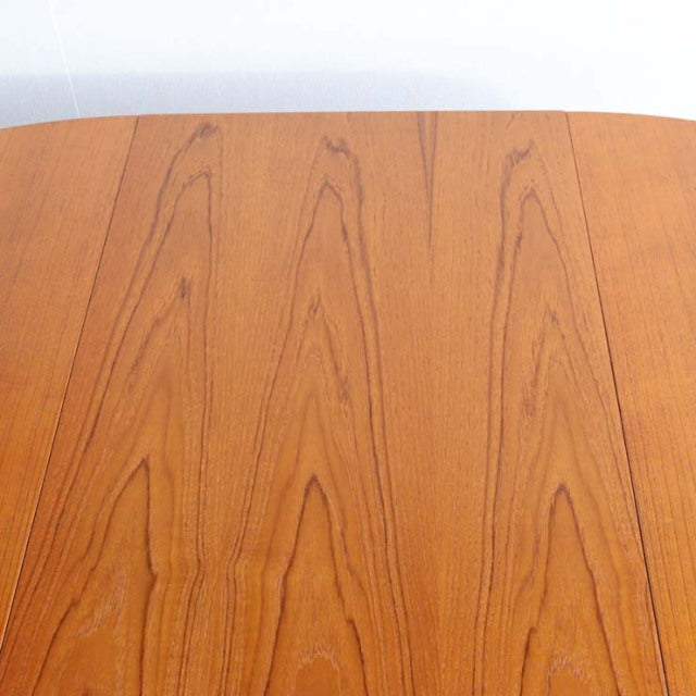 Round vintage teak dining table top showing rich wood grain, mid-century British Denmark design.