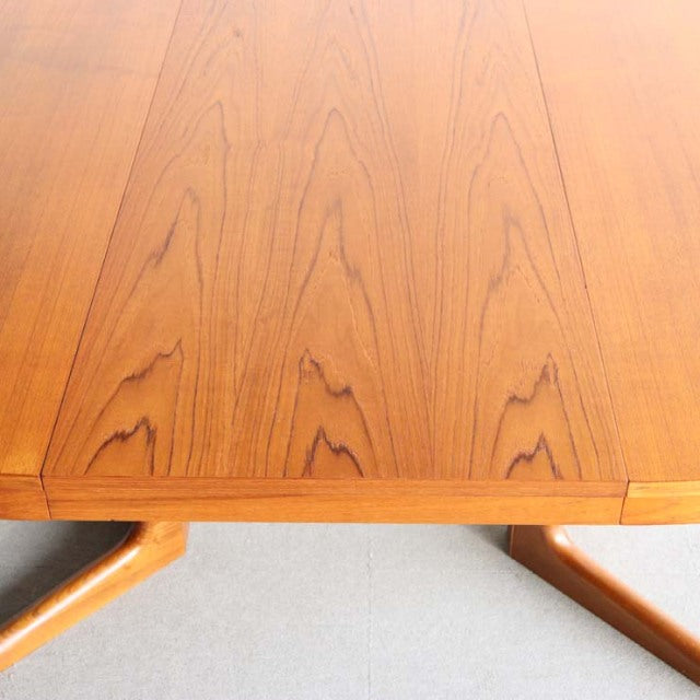 Vintage teak round dining table top with distinct wood grain from mid-century British-Denmark design, featuring angled legs.