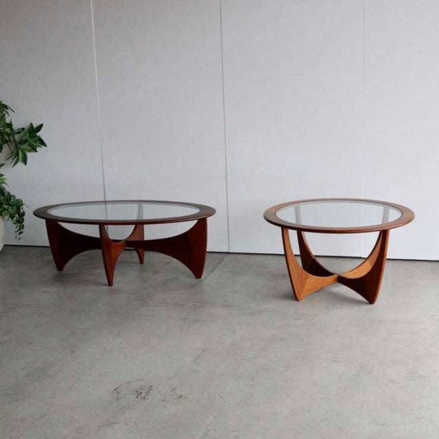 Pair of vintage G-Plan Astrolound mid-century coffee tables in teak with round glass tops and sculpted wooden legs, British.