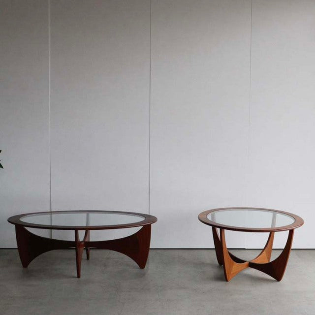 Pair of vintage mid-century British G-Plan Astrolound coffee tables with round glass tops and teak wooden bases featuring.