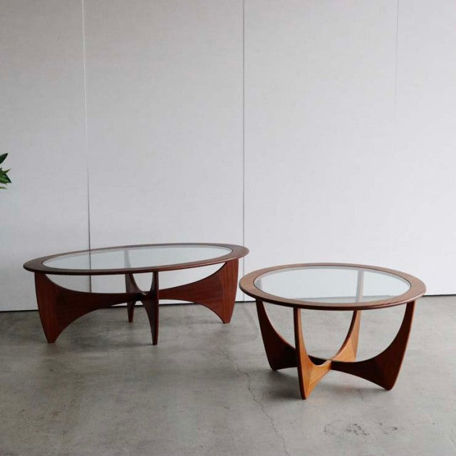 Pair of vintage G-Plan mid-century teak coffee tables with round glass tops and sculpted wooden legs, British design with.